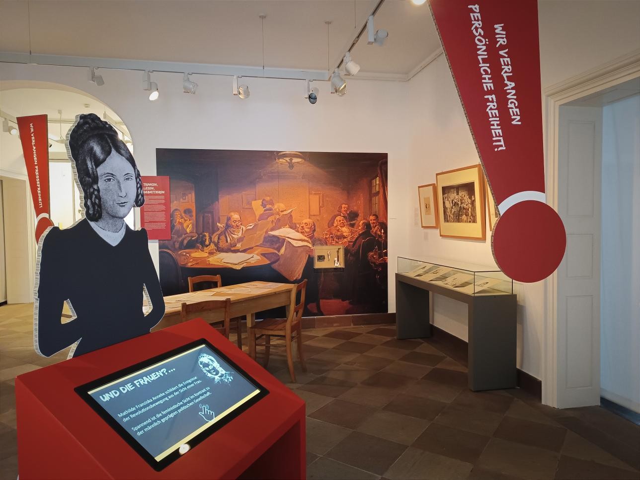 Ein Raum mit Exponaten im Stadtmuseum Rastatt, im Vordergrund ein Info-Terminal.